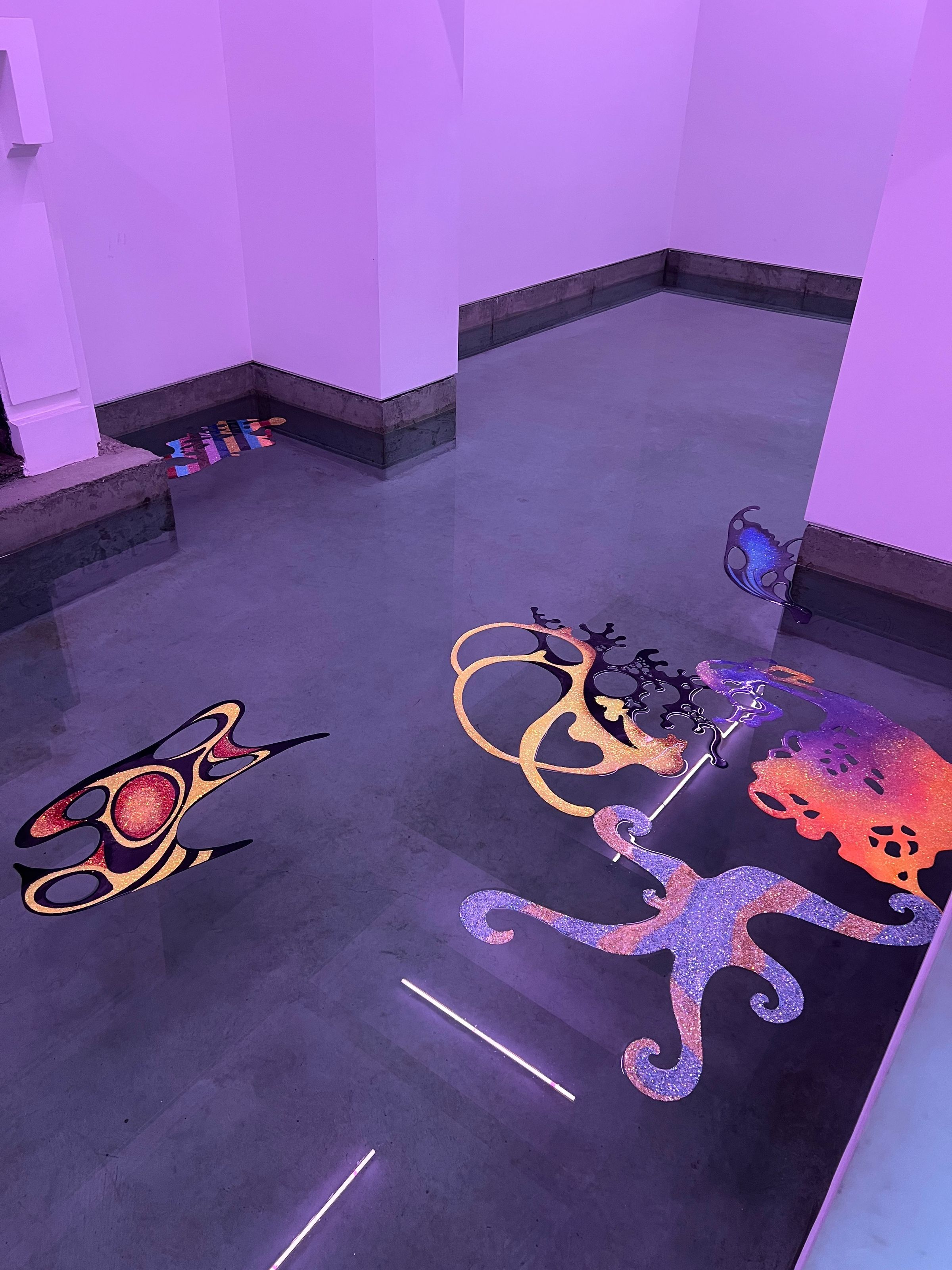 Piezas sueltas flotando por la sala, vistas desde arriba, muros bañados en luz violeta